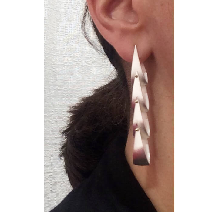 close up of silver earrings on woman